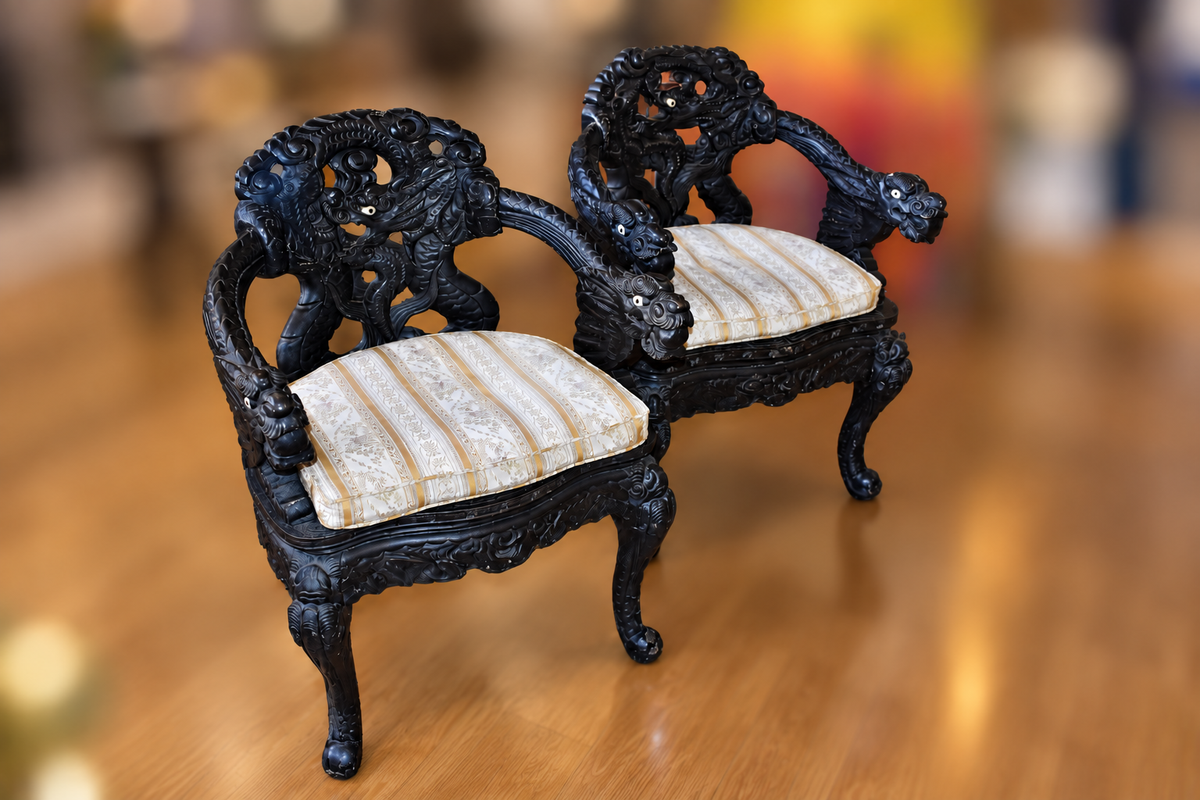 Pair of 19th-century Chinese Qing Dynasty throne chairs with dark carved frames, curved arms, and light patterned seat cushions